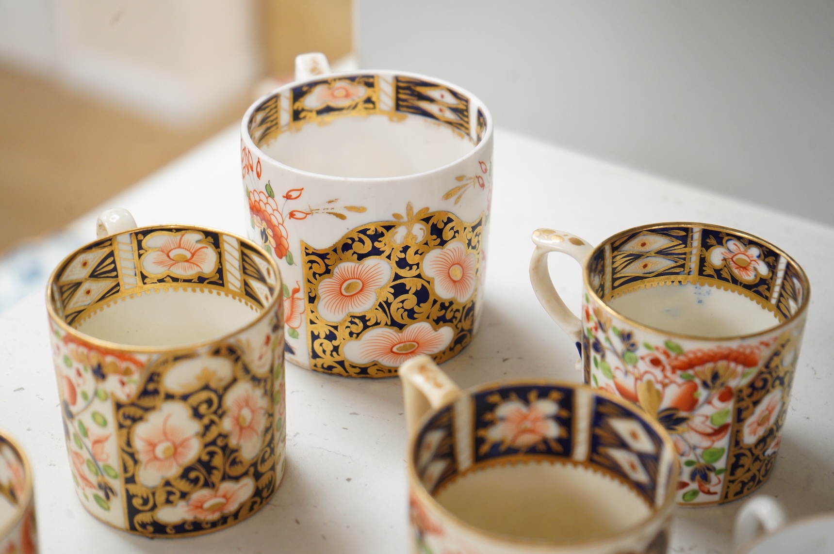 A collection of late 18th/19th century English and French porcelain coffee cans, tea cups and vases, some in Imari pattern